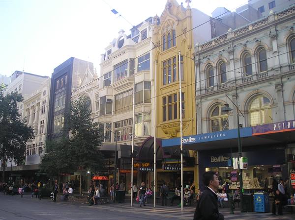 Pedestrians and shops on Swanston Street, Melbourne, historic Victorian buildings