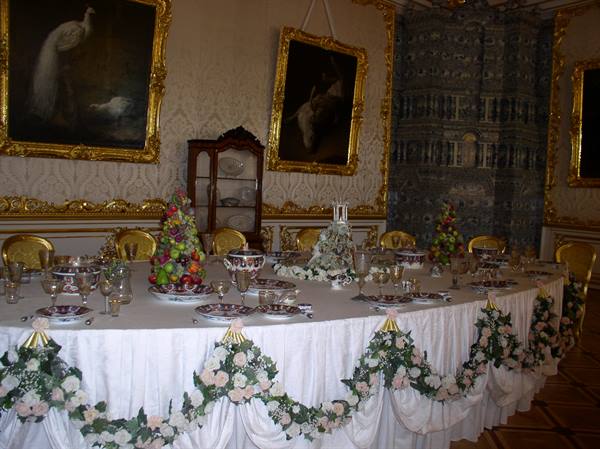 Banquet table with flower garlands in a gilded palace dining room