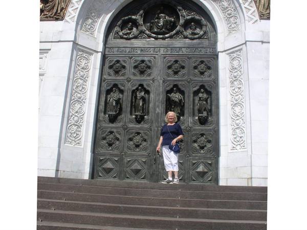 Woman on steps before the carved bronze door of Milan Cathedral