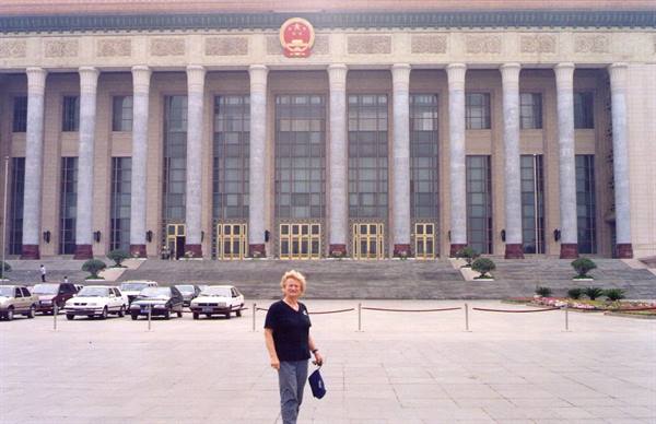 Tourist in front of the Great Hall of the People, Beijing, marble columns and parked cars
