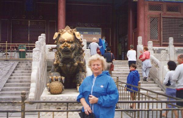 Tourist beside the bronze lion statue in the Forbidden City, Beijing