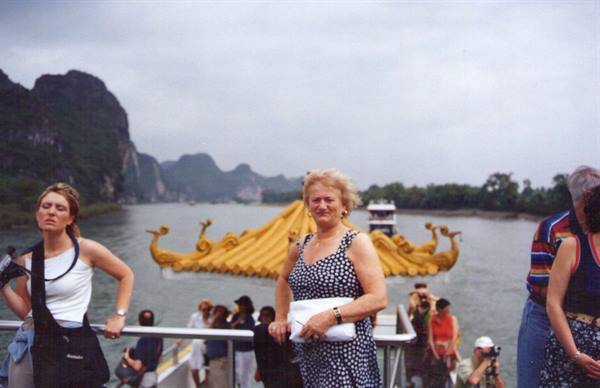 Tourists standing on a boat with golden dragon roof on the Li River, Guilin