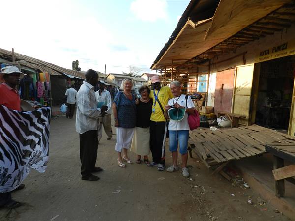 Tourists with guide among stalls at the street market