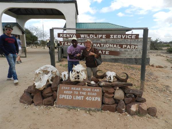 Tourist beside animal skulls at the Tsavo East National Park entrance