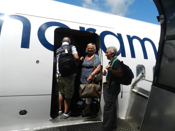Tourists with backpacks boarding a charter plane via airstair