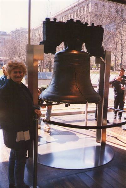 Tourist beside the bronze Liberty Bell displayed in a glass pavilion, Philadelphia