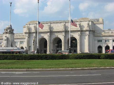 Union Station in Washington, white facade with arches, flags at half-mast and lawn