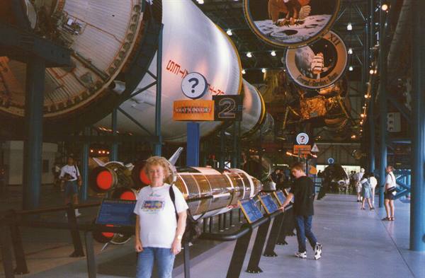 Woman standing next to the Saturn V rocket at Kennedy Space Center