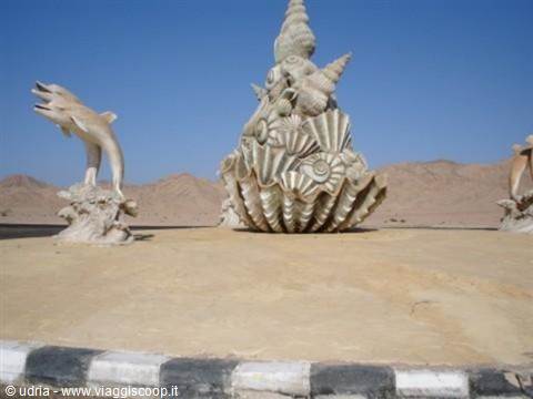 Desert roundabout with shell sculptures and white dolphin statue