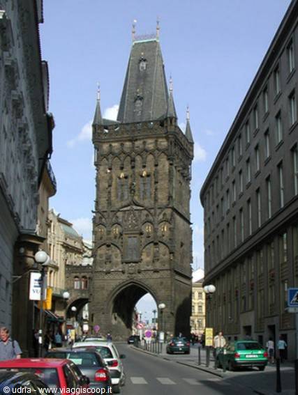 Powder Tower in Prague, gothic black stone rising over city traffic