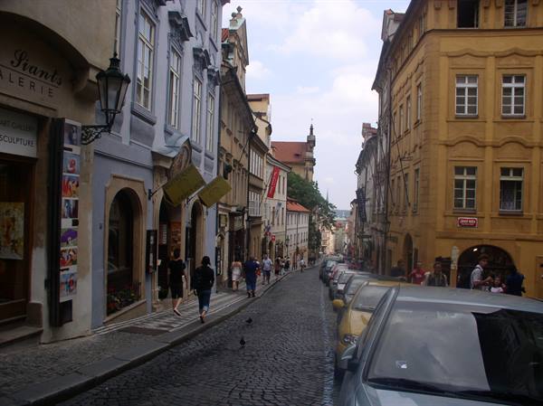 Cobblestone street with colorful buildings and pedestrians, Prague
