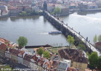 Charles Bridge in Prague crosses the Vltava, a boat passes beneath