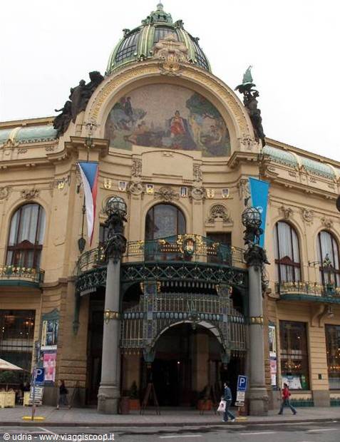 Art Nouveau facade of Prague Municipal House with mosaic, copper dome and Czech flags