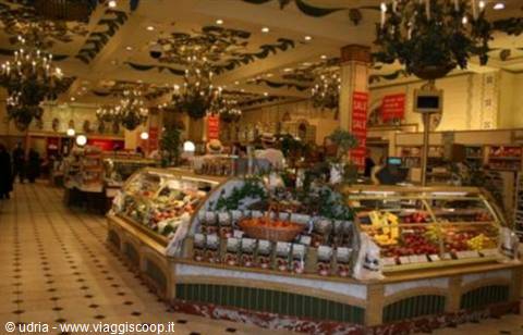 Harrods food hall: curved fruit counters, golden chandeliers and warm lights