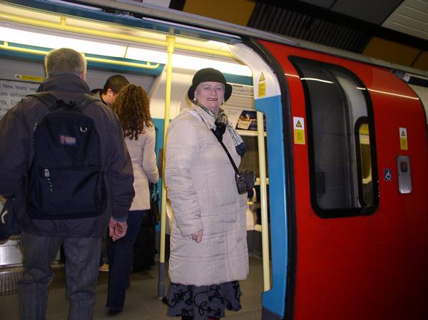 Smiling woman beside a red London Underground train carriage