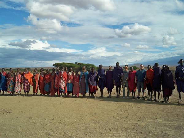 Maasai village: locals in bright red cloths and tourists lined up on dry dirt