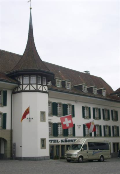 Hotel Krone with half-timbered tower and Swiss flags, van parked outside