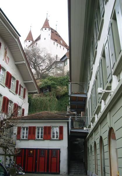 Thun Castle with white towers rising above old houses with red shutters