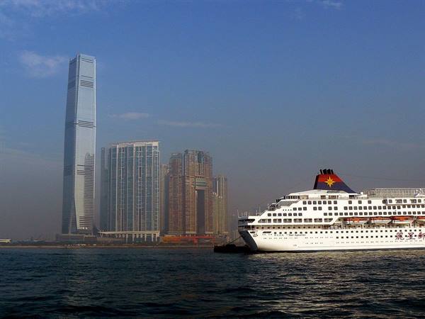 White ferry docked in Hong Kong, ICC tower looming through the haze
