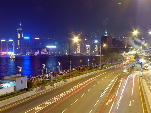 Long-exposure traffic along Hong Kong waterfront with illuminated skyscrapers