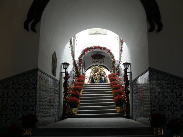 Staircase with arches adorned with poinsettias among azulejo tiles