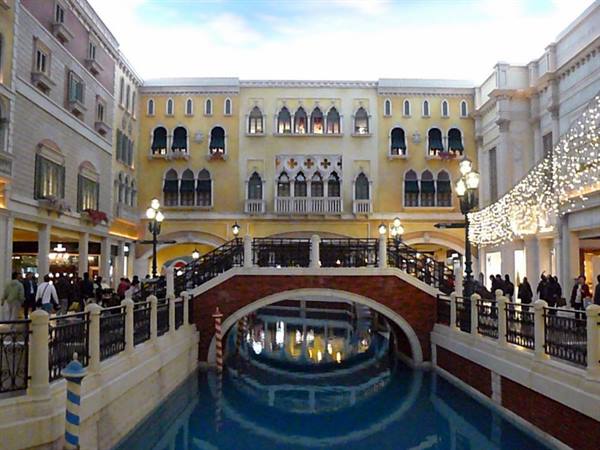 Brick bridge over the indoor canal at the Venetian Macao, painted facades and lights