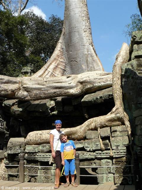 Mother and boy beneath giant roots strangling Ta Prohm temple stones