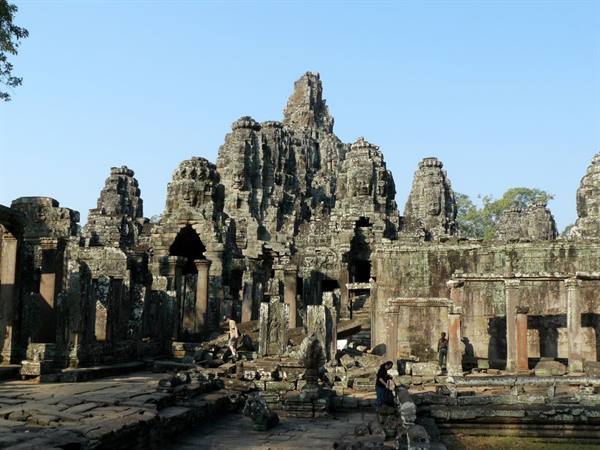 Tourists explore the stone towers of Bayon temple at Angkor