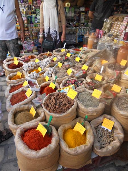 Sacks of colorful spices at the market, turmeric and paprika with yellow price tags