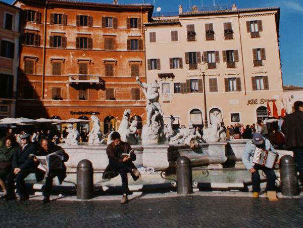 Piazza Navona, tourists and an accordion player beside the marble Moor Fountain