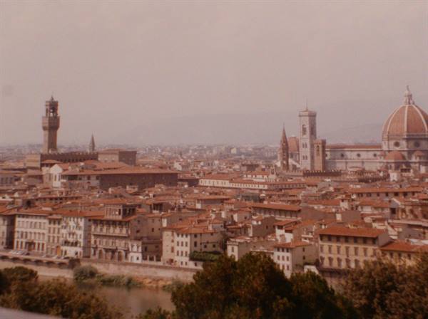 Florence: red rooftops, Palazzo Vecchio and the Duomo dome under hazy sky