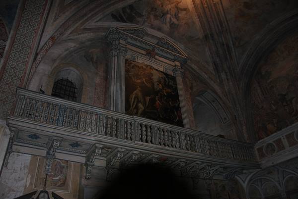 Carved stone choir balcony beneath frescoes and altarpiece inside the church