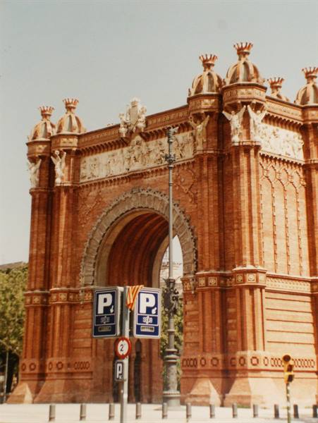 Barcelona's Triumphal Arch in red brick with statues and street signs