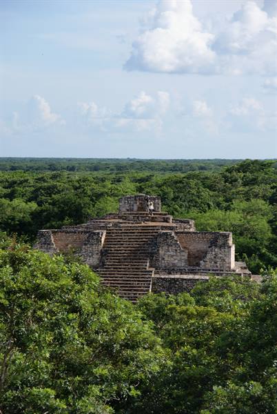Stone Maya pyramid with staircase, surrounded by green jungle at Ek Balam