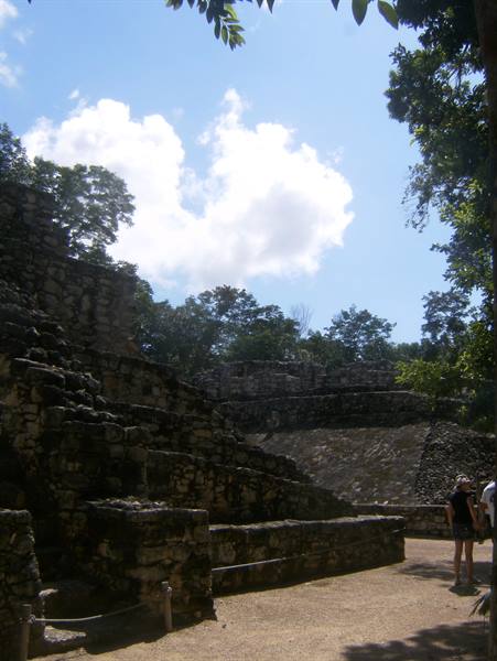Tourists beside the massive stone steps of the Cobá Maya ruins
