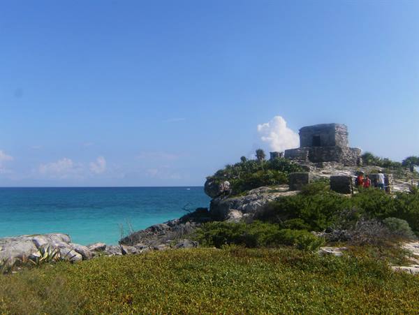 Ancient Mayan stone temple on Tulum cliff above turquoise sea