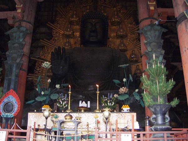 Great bronze Buddha inside Tōdai-ji temple in Nara, lit candles on altar