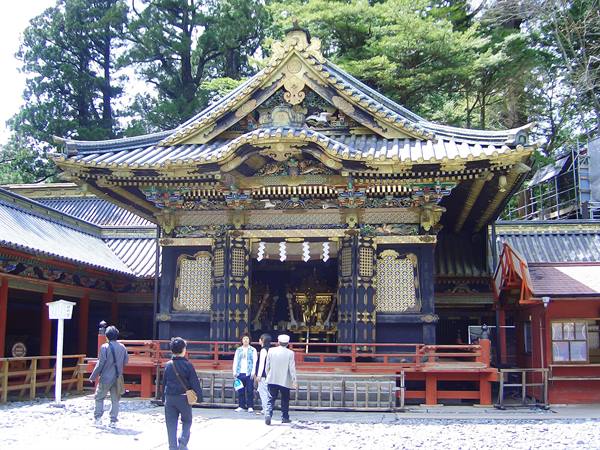 Tourists before the golden hall of Tōshōgū shrine, among tall trees