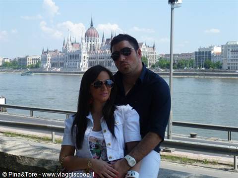 Couple in sunglasses in front of Budapest Parliament along the Danube