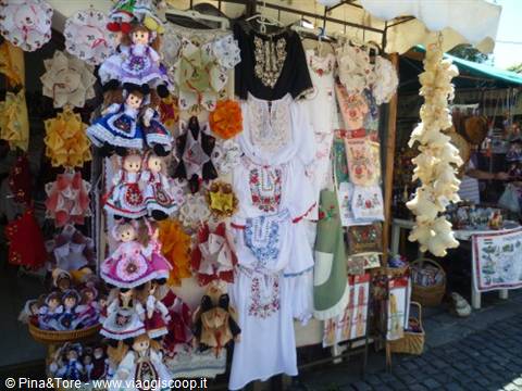 Souvenir stall with traditional dolls and embroidered folk clothing hanging