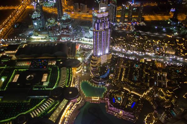 Illuminated skyscrapers of Downtown Dubai seen from above at night, with the fountain lake