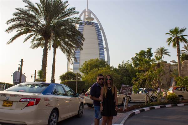 Couple posing beside a taxi in front of Burj Al Arab, Dubai