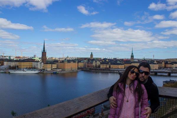 Couple embracing on wooden terrace behind Stockholm and Riddarholmen