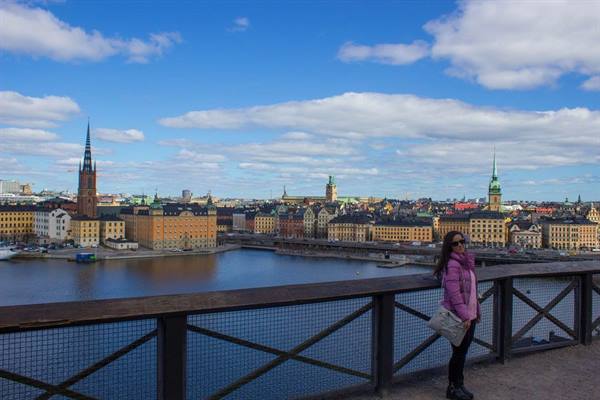 Woman in pink jacket by the railing, Riddarholmen and Gamla Stan, Stockholm
