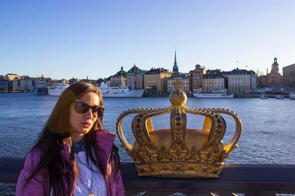 Woman beside the golden crown on Skeppsholmsbron bridge, Stockholm
