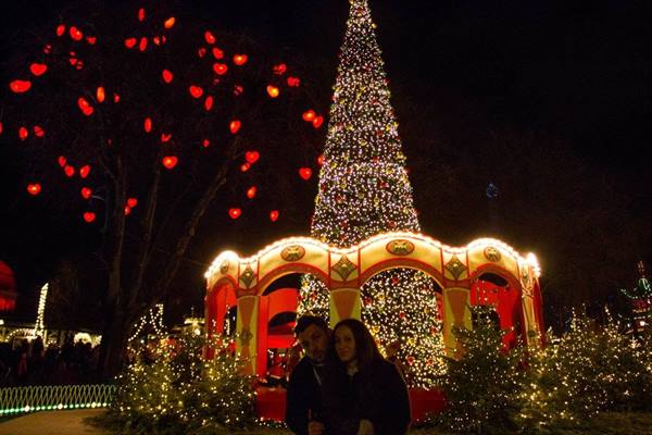 Couple in front of the illuminated Christmas tree at Tivoli Gardens, Copenhagen
