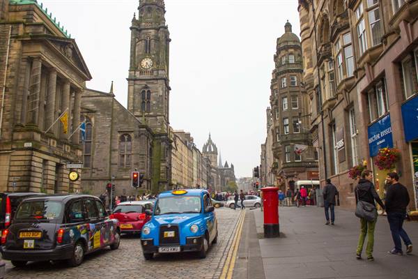 Blue taxi on the Royal Mile, Edinburgh, near Tron Kirk clock tower
