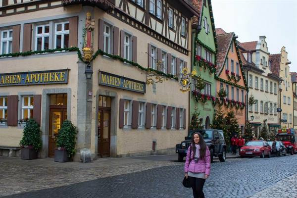Woman in pink jacket in front of the Marien-Apotheke in Rothenburg ob der Tauber