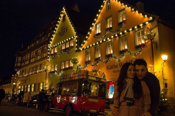 Couple outside the illuminated Käthe Wohlfahrt Christmas shop in Rothenburg