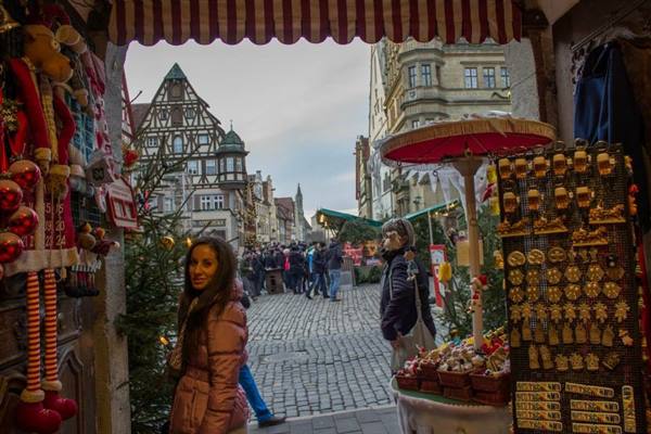 Smiling woman among Christmas stalls, timbered houses and cobblestones, Rothenburg ob der Tauber
